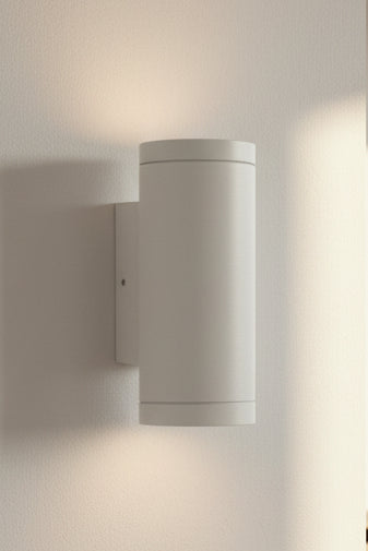 A cylindrical up and down light LED fixture with a matte white finish, mounted on a surface.