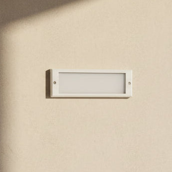 Matt white LED step light fixture mounted on an orange wall, with a label indicating the model and power specifications.